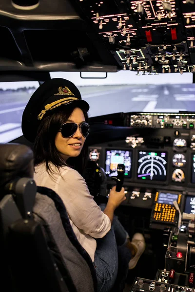 Piloto femenino en la cabina del avión. Piloto con gafas de sol y sombrero —  Fotos de Stock