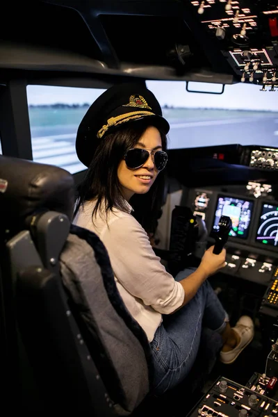 Γυναίκα πιλότος στο πιλοτήριο αεροπλάνου. Πιλότος φορώντας γυαλιά ηλίου και καπέλο — Φωτογραφία Αρχείου