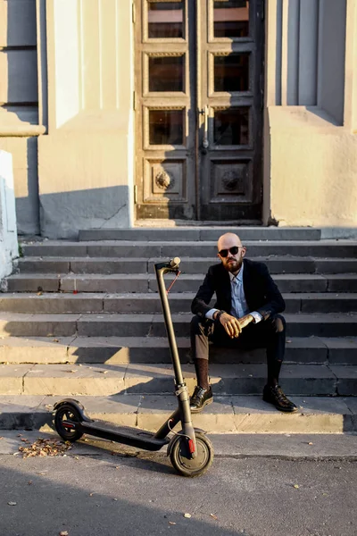 Entreprise et les gens et le concept - jeune homme d'affaires équitation scooter électrique à l'extérieur — Photo