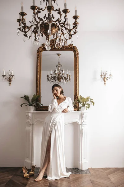 Moderne bruid in een luxe interieur. Mooie jonge bruid in witte trouwjurk binnenshuis — Stockfoto