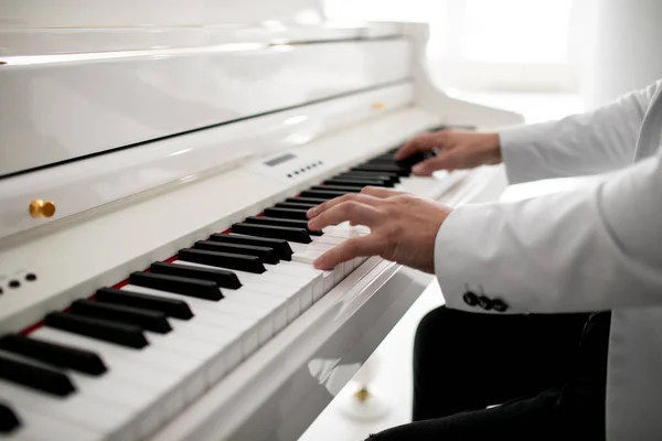 Close up of man hands piano playing. Male pianist hands on grand piano keyboard