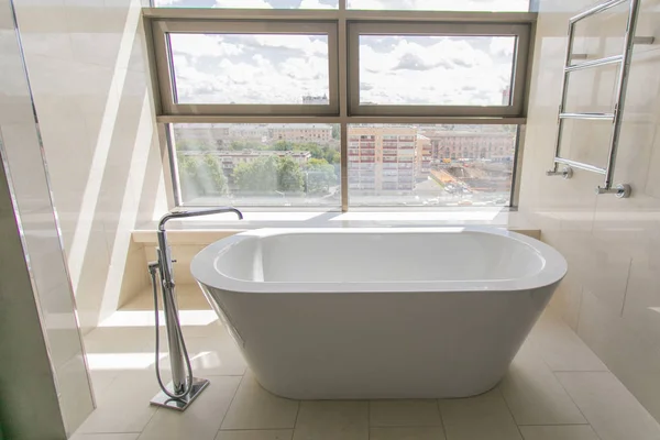 Interior de banheiro branco puro com banheira separada. Banheiro com grandes janelas — Fotografia de Stock