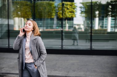 Mutlu iş kadını telefonda konuşuyor. Ofis binası geçmişi