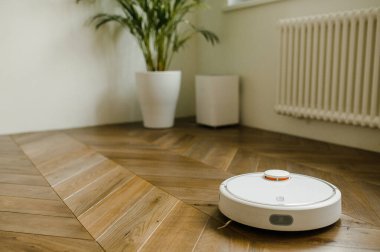 Robot elektrikli süpürge yatak odasında lamine ahşap zemin üzerinde