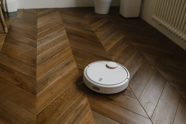 Robot elektrikli süpürge yatak odasında lamine ahşap zemin üzerinde