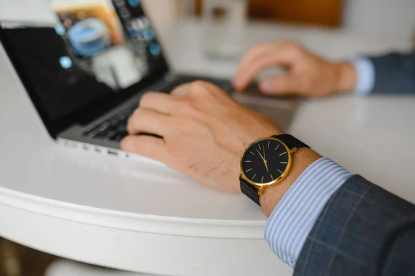 Mężczyzna w czarnym zegarku pracuje na laptopie — Zdjęcie stockowe