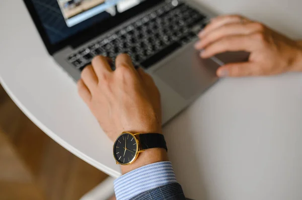 Ein Mann mit schwarzer Uhr arbeitet an einem Laptop — Stockfoto