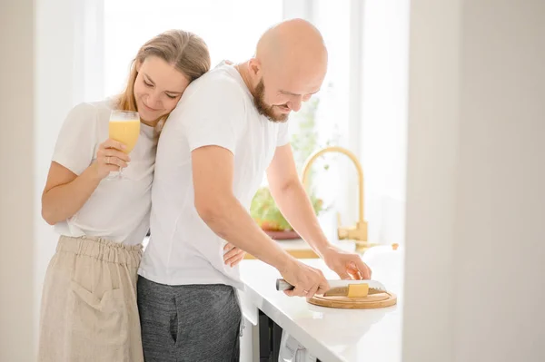 Glückliches junges Paar bereitet Frühstück zu und genießt einander — Stockfoto