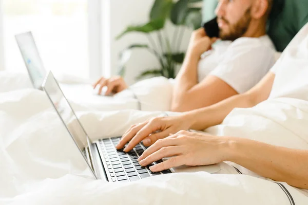 Young couple uses laptop in bed. freelancer morning. — Φωτογραφία Αρχείου