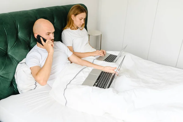 Νέοι άνθρωποι στο σπίτι ή χιλιετή όμορφο ζευγάρι στο ξενοδοχείο χρησιμοποιώντας σύνδεση στο internet και συσκευές τεχνολογίας, όπως φορητό υπολογιστή — Φωτογραφία Αρχείου