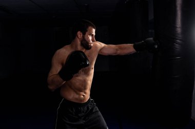  Esmer arka plandaki boksör, fitness kulübü için bir boks çantasındaki fotoğrafa doğrudan isabet ettirdi.