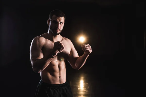 Thai boxer in good physical shape on a dark background