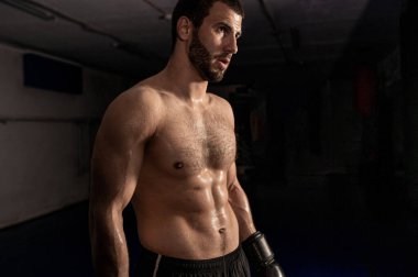  Eğitimden sonra siyah arkaplanda boks eldivenli bir boksör