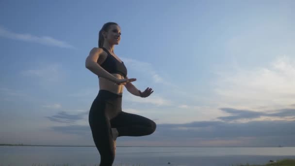 Yoga en una playa. Modelo de fitness que hace ejercicio al aire libre. Concepto de estilo de vida saludable. — Vídeo de stock