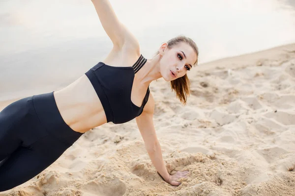 Löpare kvinna stretching ben med lunge hamstring stretch motion ben sträcker. Fitness kvinnlig idrottsman avkopplande på stranden — Stockfoto