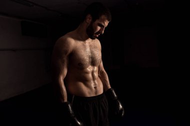  Eğitimden sonra siyah arkaplanda boks eldivenli bir boksör