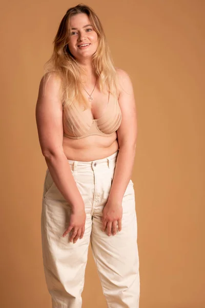 Bella donna in sovrappeso in costume da bagno beige su sfondo rosa — Foto Stock