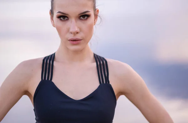 Retrato de cerca de un hermoso modelo de fitness contra el mar al atardecer — Foto de Stock