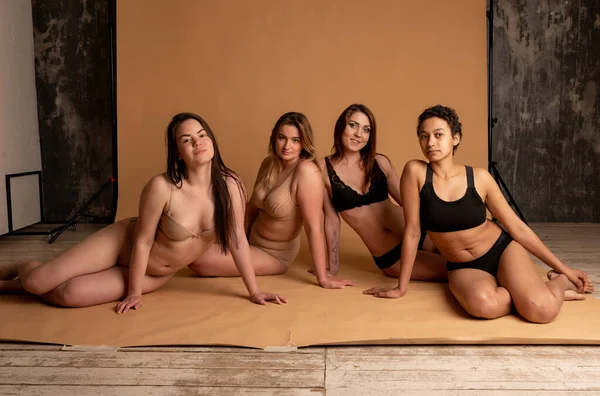 Amizade, beleza, corpo positivo e conceito de pessoas - grupo de mulheres felizes diferentes em roupas íntimas sobre fundo cinza — Fotografia de Stock