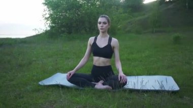 Mutluluk portresi. Yoga yapan genç bir kadın. Yoga ve rahatlama konsepti. Güzel kız Asana antrenmanı yapıyor.