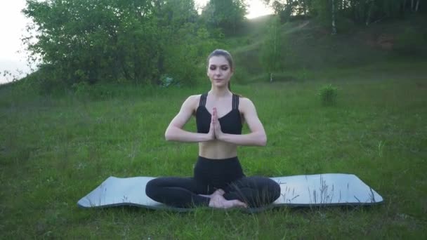 Portret szczęśliwej młodej kobiety ćwiczącej jogę na świeżym powietrzu.Koncepcja jogi i relaksu. Piękna dziewczyna praktyka asana — Wideo stockowe