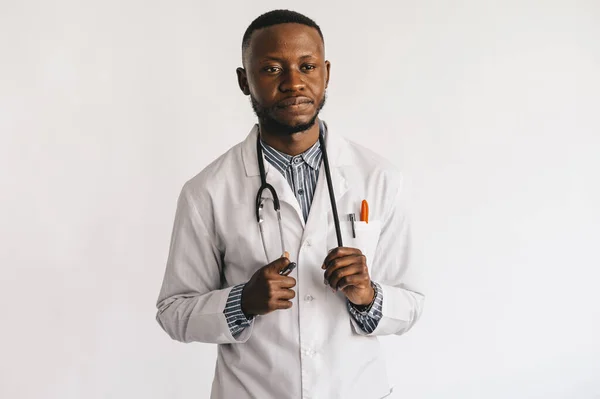 Zbliżenie zdjęcie młodego Afroamerykanina lekarza stojącego w białym mundurze na białym tle — Zdjęcie stockowe