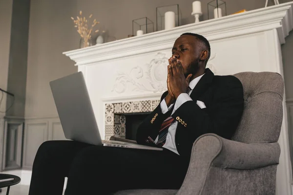 スーツを着た黒人ビジネスマンに焦点を当て、ラップトップ上のクライアントとビデオ通話を保持する。オンライン会議コンサルティングの顧客を与える訴訟に集中100万人の男 — ストック写真