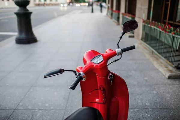 Red vintage scooter parked on sidewalk of empty city street — Stock Photo, Image