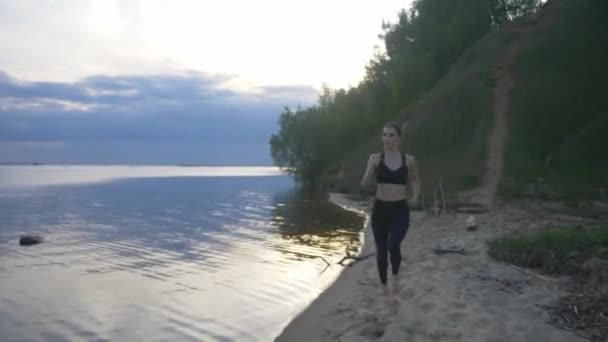 한 젊은 운동 선수가해 질 때 해변으로 달려간다. 거리에서 스포츠를 하는 운동 선수 소녀 — 비디오