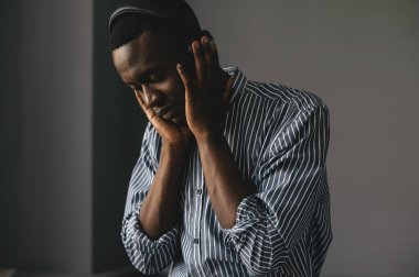Afro-Amerikalı adam, şık bir gömlek giymiş, kulaklık takmış müzik dinliyor, müzik dinliyor, dans ediyor. 
