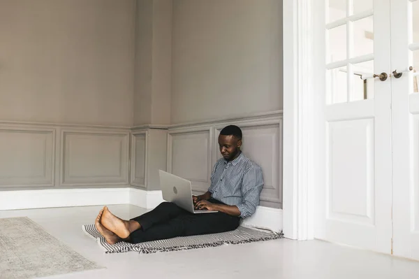 Sempre faça um esforço total, mesmo quando as probabilidades estão contra você. Empresário afro-americano está trabalhando, usando seu laptop enquanto descansa em casa — Fotografia de Stock