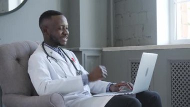 Dizüstü bilgisayar kullanan Afro-Amerikan bir doktorun portresi. çevrimiçi danışma