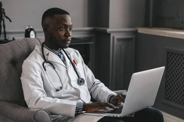 Afroamerykański lekarz prowadzi konsultacje w zakresie telemedycyny poprzez przekazywanie informacji medycznych kanałami telekomunikacyjnymi — Zdjęcie stockowe