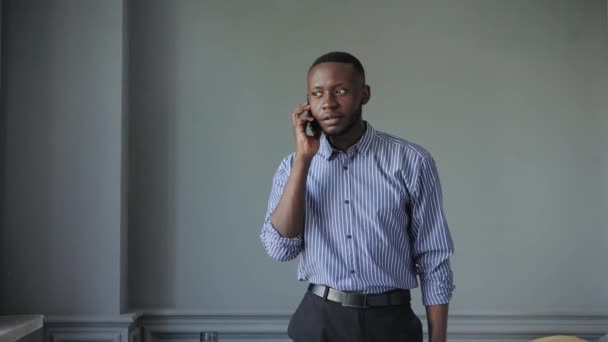 The African-American answered the phone and got some very good news. happy african guy euphoric looking at cell phone celebrate good news victory success — Stock Video