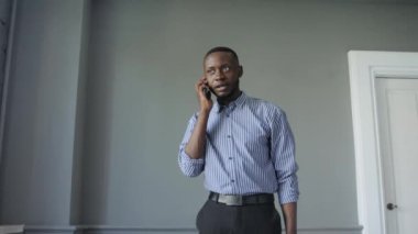 Genç başarılı siyah işadamı telefonu kullanıyor, iyi haber mutlu bir gülümseme. Başarı ve başarı kavramı