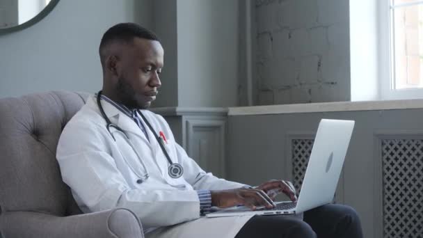 Um médico afro-americano fornece consultas de telemedicina através da transmissão de informações médicas através de canais de telecomunicações — Vídeo de Stock