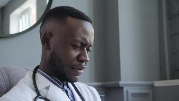 Ärztliche Beratung in Echtzeit. Ein afroamerikanischer Arzt führt Konsultationen zur Videokommunikation durch — Stockvideo