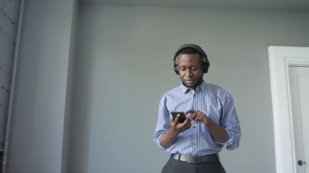 Black man with headphones listening to music and enjoying and slowly dancing — Stock Video