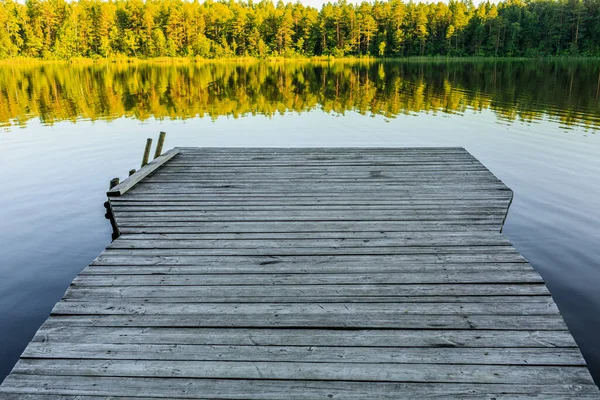 Wooden pier. The bridge to the lake under the sunset — Stock Photo, Image