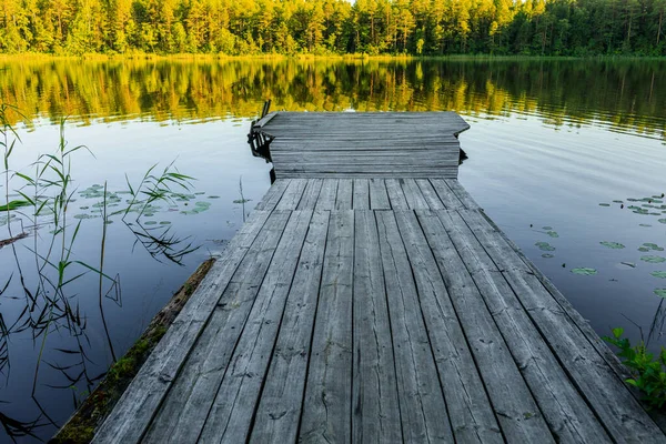 Wooden pier. The bridge to the lake under the sunset — Stock Photo, Image