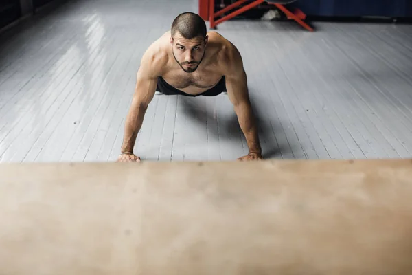 Спортсмен в темных шортах отжимается. workout — стоковое фото