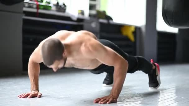 Joven atleta muscular haciendo flexiones de suspensión — Vídeo de stock