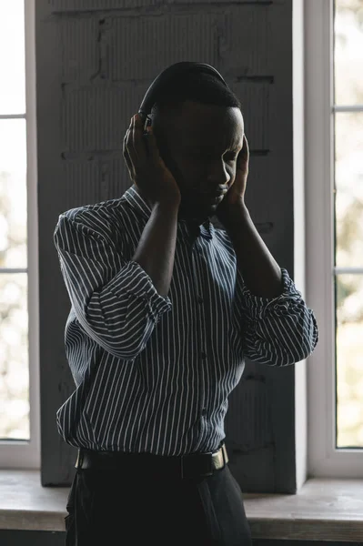 Homem afro-americano em camisa elegante em fones de ouvido ouvir música e desfrutar de música, dança — Fotografia de Stock