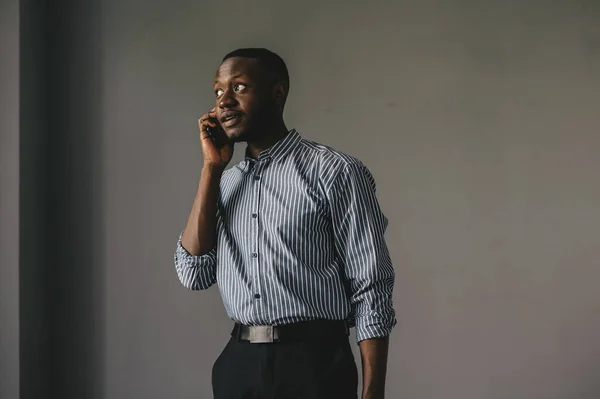 the African-American answered the phone and got some very good news. happy african guy euphoric looking at cell phone celebrate good news victory success