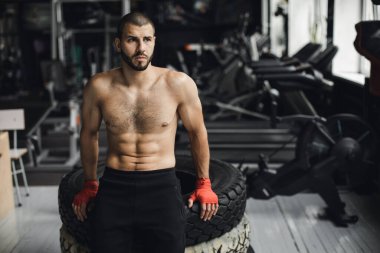 Gözleri kapalı yakışıklı vücut geliştirici spor salonunda balyoz egzersizi yaptıktan sonra dinleniyor. Tam uzunlukta kenar görünüm fotoğrafı
