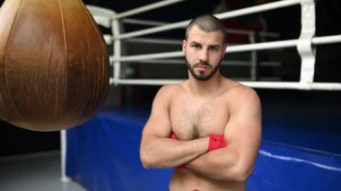 Çıplak göğüslü boksör ringin yanında duruyor. Boks