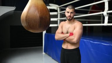 Çıplak göğüslü boksör ringin yanında duruyor. Boks