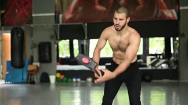 Gözleri kapalı yakışıklı vücut geliştirici spor salonunda balyoz egzersizi yaptıktan sonra dinleniyor. tam uzunluk kenar görünümü 