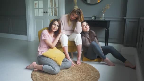 Three friends are sitting on the roof of the house and chatting — Stock Video