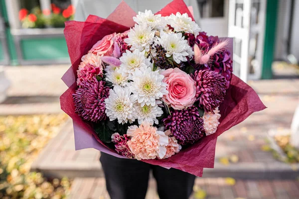 Vacker bukett av blandade blommor i kvinnors händer. blomsterhandlarens arbete i en blomsteraffär. Snygg fräsch bukett — Stockfoto